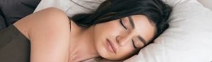Woman asleep on a mattress.