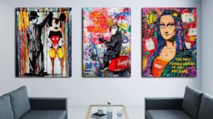 Three colorful pop art canvas prints featuring iconic artistic figures displayed above a modern seating area, adding bold visual interest to a contemporary living room.