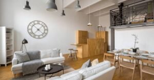 Modern studio apartment interior with an open-plan living area, loft bedroom, multifunctional furniture, and space-saving design.