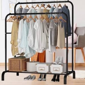 Freestanding double clothing rack with hanging garments, wooden hangers, woven baskets, storage boxes, and shoes neatly organized below in a modern bedroom.