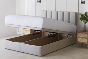 Modern upholstered ottoman bed with a side-lift hydraulic storage mechanism, revealing spacious hidden compartments beneath the mattress in a minimalist bedroom.