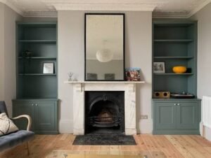 Built-in wall shelving and lower cabinets on either side of a traditional fireplace, creating stylish and functional storage in a modern living room.