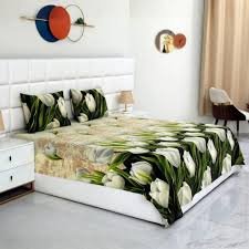 Modern bedroom with a tropical leaf print bed sheet and matching pillowcases on a white upholstered bed, creating a fresh and stylish atmosphere.